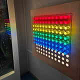Colorful LED light panel on a ceiling with a reflection below.