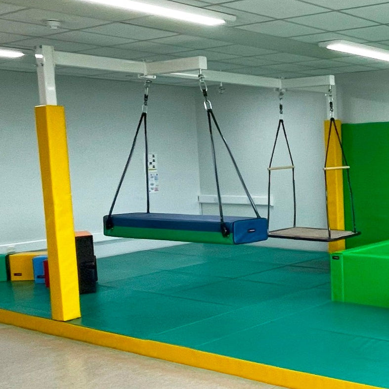 Colorful indoor playground with various equipment in a room.