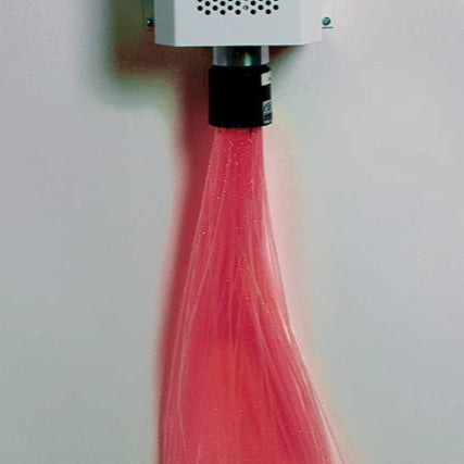 Pink fiber optic cable on a carpeted floor with a white wall background