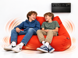 Two boys sitting on a large orange bean bag chair, laughing and looking at a black soundwave control panel mounted on the wall above them. The bean bag is surrounded by orange soundwave graphics on a white background.