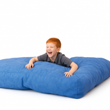 Child playing on a large blue cloud nine crash pillow